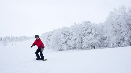 Young Asian woman practice downhill sliding snowboard on snow mountain at ski resort. Attractive girl enjoy outdoor active lifestyle travel nature and winter extreme sport training on holiday vacation