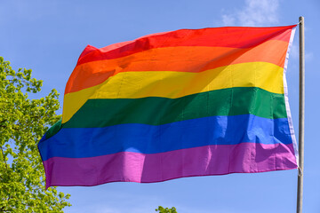 Gay pride rainbow colours flag and blue sky