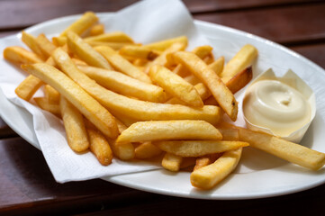 Eating of street or take away food fresh baked french fried potatoes chips with Belgian mayonnaise