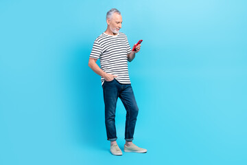Photo of handsome retired man wear striped outfit chatting writing instagram facebook followers isolated on blue color background