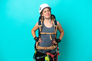 Young Italian rock-climber woman isolated on blue background suffering from backache for having made an effort