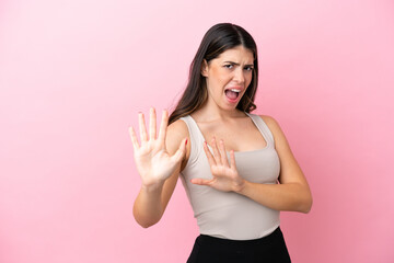 Young Italian woman isolated on pink background nervous stretching hands to the front