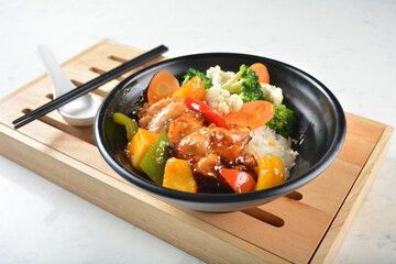 hawaiian sweet and sour grilled chicken pineapple rice bowl with fried vegetable salad in black...