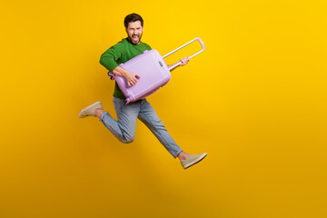 Full body length photo of crazy screaming young man guitarist holding luggage suitcase jumper singing isolated on yellow color background