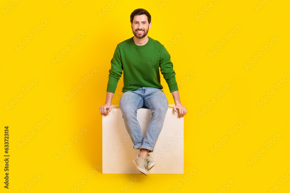 Poster Full length body photo of cheerful young satisfied marketolog businessman guy sitting white box podium isolated on yellow color background