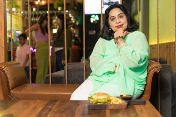 Senior woman sitting, food arrange in front of table at restaurant