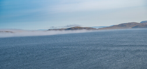 Beautiful view of the sea with a strip of fog from the tundra coast