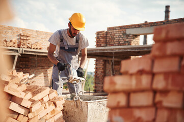 Mixes concrete. Handsome Indian man is on the construction site