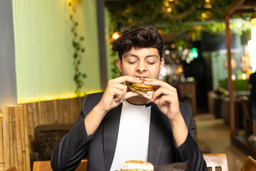 Young indian boy eating food at restaurant