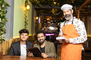 Indian man ordering food to waiter at restaurant