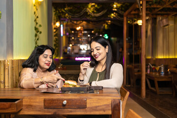 Indian women enjoying food at restaurant