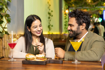 Indian Couple enjoying food and drink at restaurant