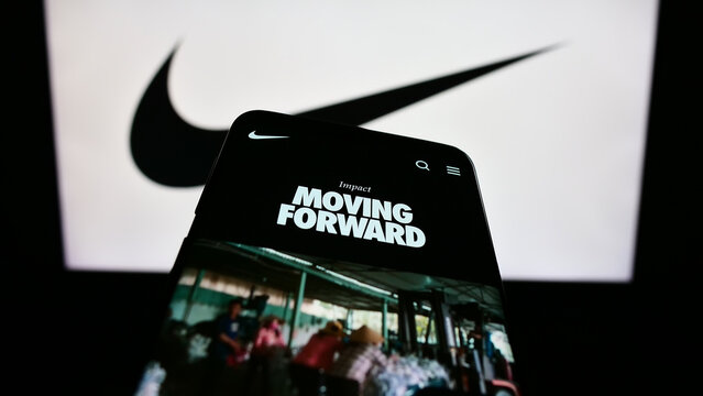 Stuttgart, Germany - 08-06-2023: Mobile phone with webpage of US sportswear company Nike Inc. on screen in front of business logo. Focus on top-left of phone display.