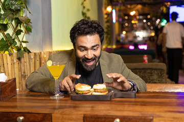 Fototapeta na wymiar Indian man enjoying fast food at restaurant