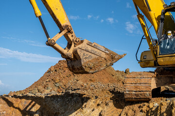 close-up of excavator claws, dirty hands of an excavator working shoveling hilly soil