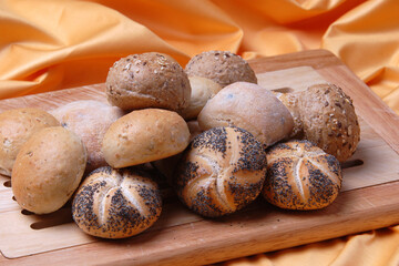 Different kinds of bread rolls on black board from above