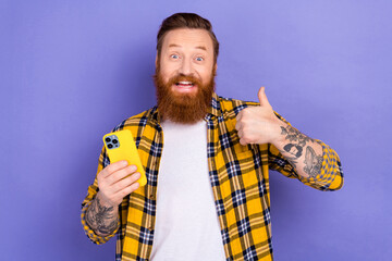 Photo of excited handsome person hold smart phone demonstrate thumb up telegram tiktok instagram...