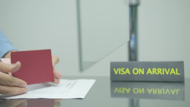 Custom officer checking and putting visa stamp in passport at the airport