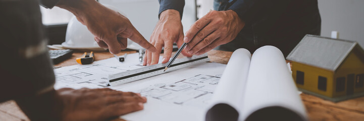 Team of engineers reviewing blueprints Sketch of a new construction project with engineering tools at office desk. For improvement of house designs in mortgage, rent, sale, real estate