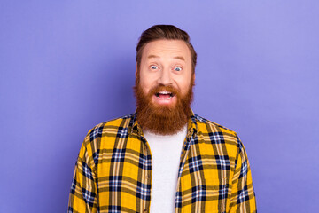 Portrait of funny excited red hair bearded guy wear plaid shirt clothes open mouth hear good news isolated purple color background
