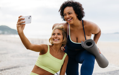 Beach workout friends taking a selfie together after a yoga session