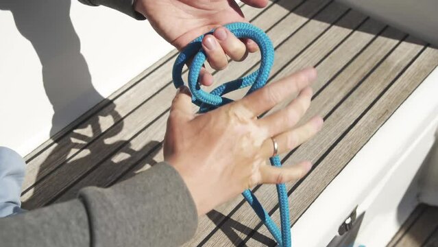 Tying a rolling Clove Hitch. Close-up. Blue knot. Knot for attaching. Tying knots on a sailing boat. Sailing. 4К