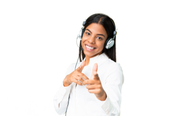 Telemarketer African American woman working with a headset over isolated chroma key background pointing to the front and smiling