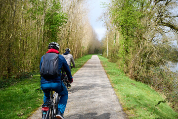 Obraz premium two people riding bicycle in Val de Cher in France in the spring