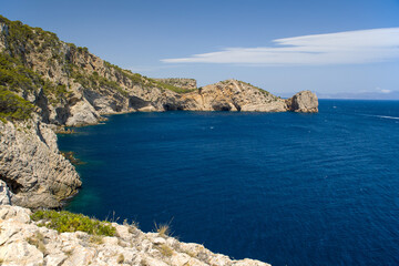 Fototapeta premium the bay gulf de la morisca with the rock gate La Foradada in sunny sky and a ship passing by