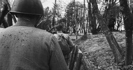 Re-enactors Dressed As Soviet Russian Soldiers take up fighting positions in trenches. Position Defense. Soldiers Aiming With Rifles. Reconstruction Of Battles World War Ii. Black And White . - obrazy, fototapety, plakaty