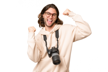 Young photographer man over isolated background celebrating a victory