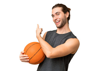 Young basketball player man over isolated background pointing back