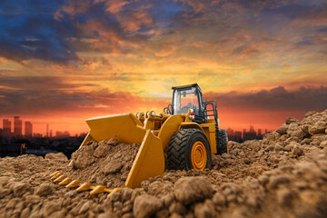 Wheel loader are digging the soil in the construction site on the cloud  sky background .