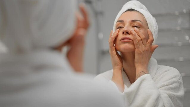 Beautiful lady delicately applying facial serum as part of her skincare routine.Perfect for beauty and skincare related projects