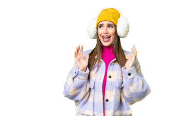 Young woman wearing winter muffs over isolated chroma key background with surprise facial expression