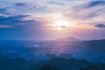 Blue sky with white dynamic clouds over the city at dusk at sunset. View of the urban landscape from Dajianshan Mountain, New Taipei City, Taiwan