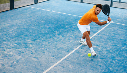 Competitive padel player receives shot on court in sports tournament