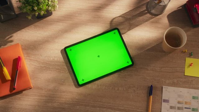 Tablet Computer with Mock Up Green Screen Chromakey Display with Motion Trackers. Elevated Zoom In Rotating Footage of a Device on a Creative Wooden Desk with Notebook, Pen, Calendar and Hot Coffee