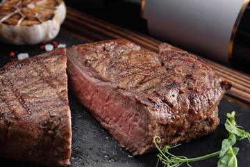 Meat steak medium, on a board with a stone and a bottle of wine
