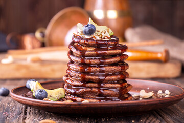 Vegan pancakes based avocado with cocoa and date syrup. Vegan healthy sweet food. Rustic background...