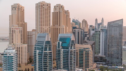 Fototapeta na wymiar Dubai Marina skyscrapers and JBR district with luxury buildings and resorts aerial night to day timelapse