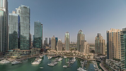 Obraz premium Panorama showing Dubai marina tallest skyscrapers and yachts in harbor aerial timelapse.