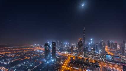 Fototapeta na wymiar Aerial view of tallest towers in Dubai Downtown skyline and highway night timelapse.