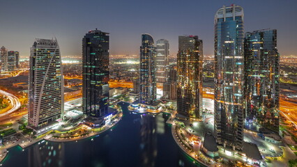 Fototapeta na wymiar Tall residential buildings at JLT aerial day to night timelapse, part of the Dubai multi commodities centre mixed-use district.