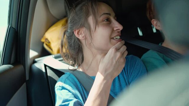 happy laughing young woman hipster in car during car travel with friends. wunderlast and journey, adventure summer vacation. long road passenger. itting in rear seat and having fun on a road trip.