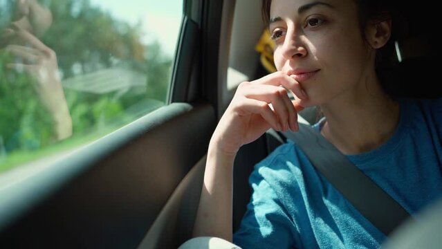 happy laughing young woman hipster in car during car travel with friends. wunderlast and journey, adventure summer vacation. long road passenger. itting in rear seat and having fun on a road trip.
