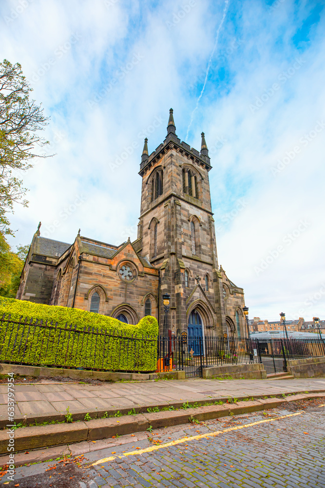 Wall mural greenside parish church behind green tree leaves