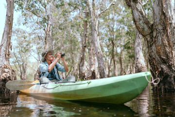 Asian man rowing a boat on a river in the Asian forest Taking pictures in the mangrove forest