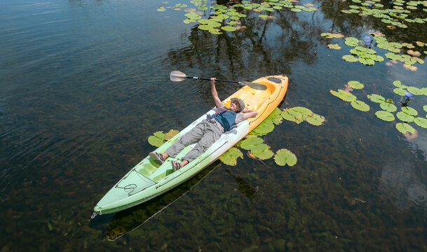 Asian man rowing a boat on a river in the Asian forest Lie down and relax peacefully.