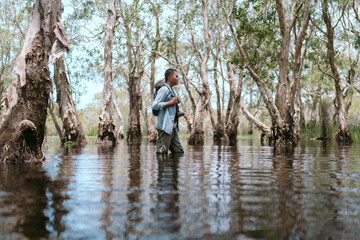 Fototapeta na wymiar Asian man traveling alone in the mangrove forest Asian rivers and forests.